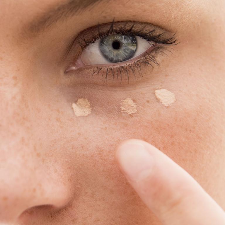 Woman applying concealer