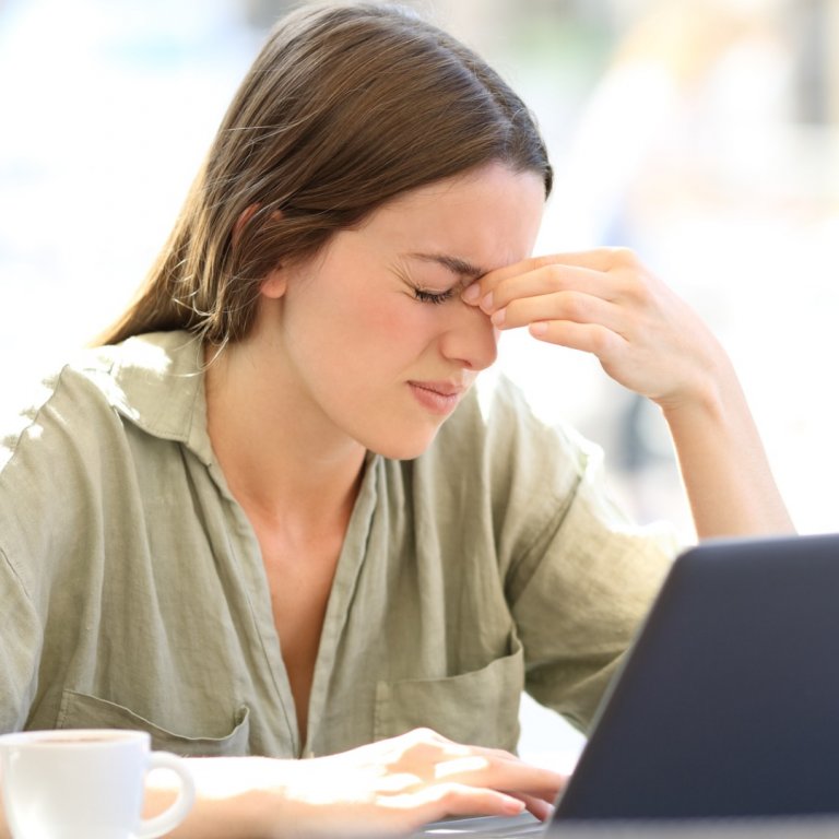 woman with headache working at laptop