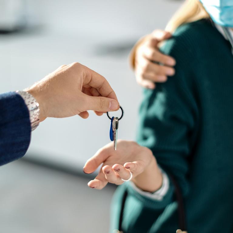 couple wearing masks getting new house keys